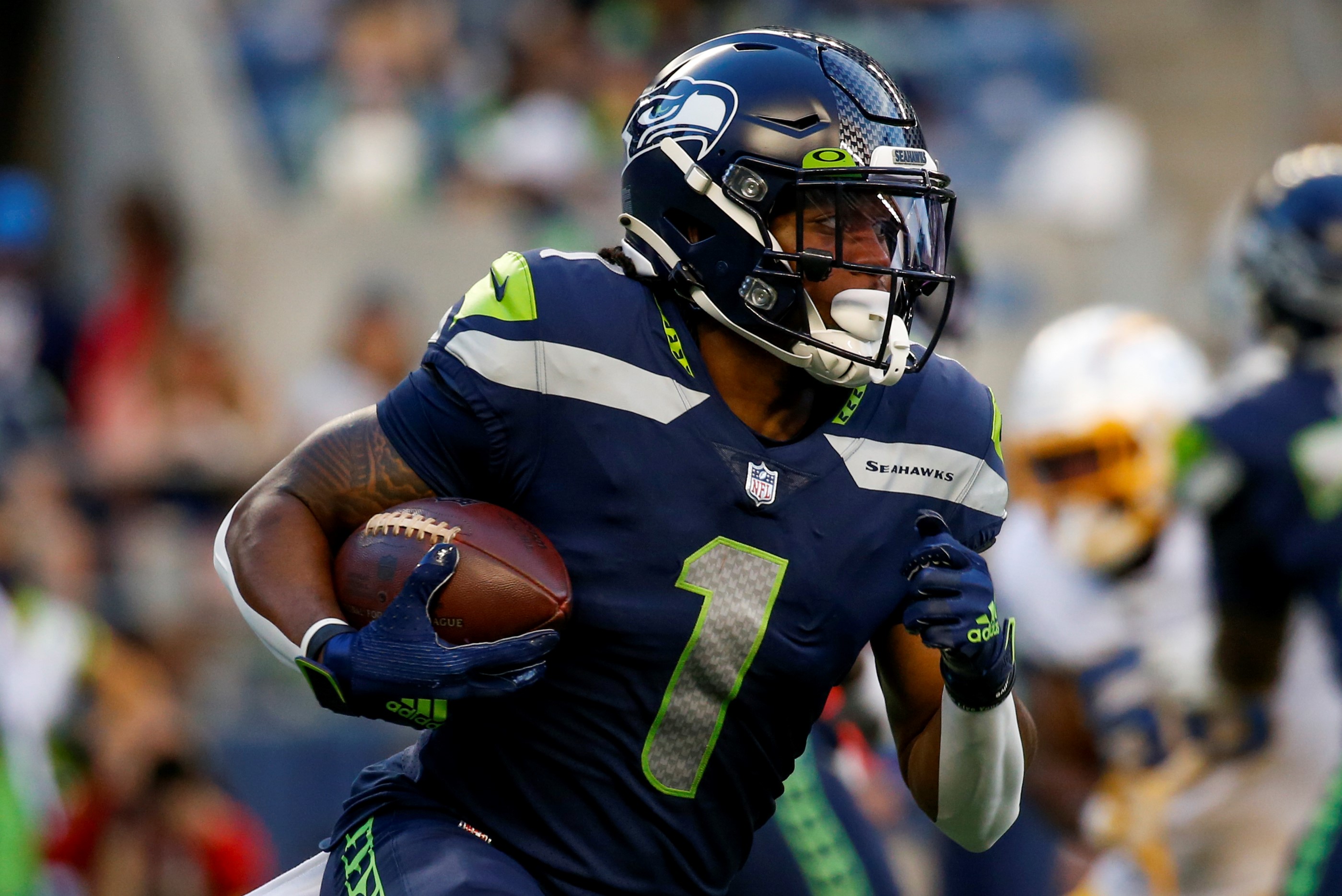 Seattle Seahawks wide receiver D'Wayne Eskridge (1) runs the ball against the Los Angeles Chargers during the first quarter at Lumen Field.