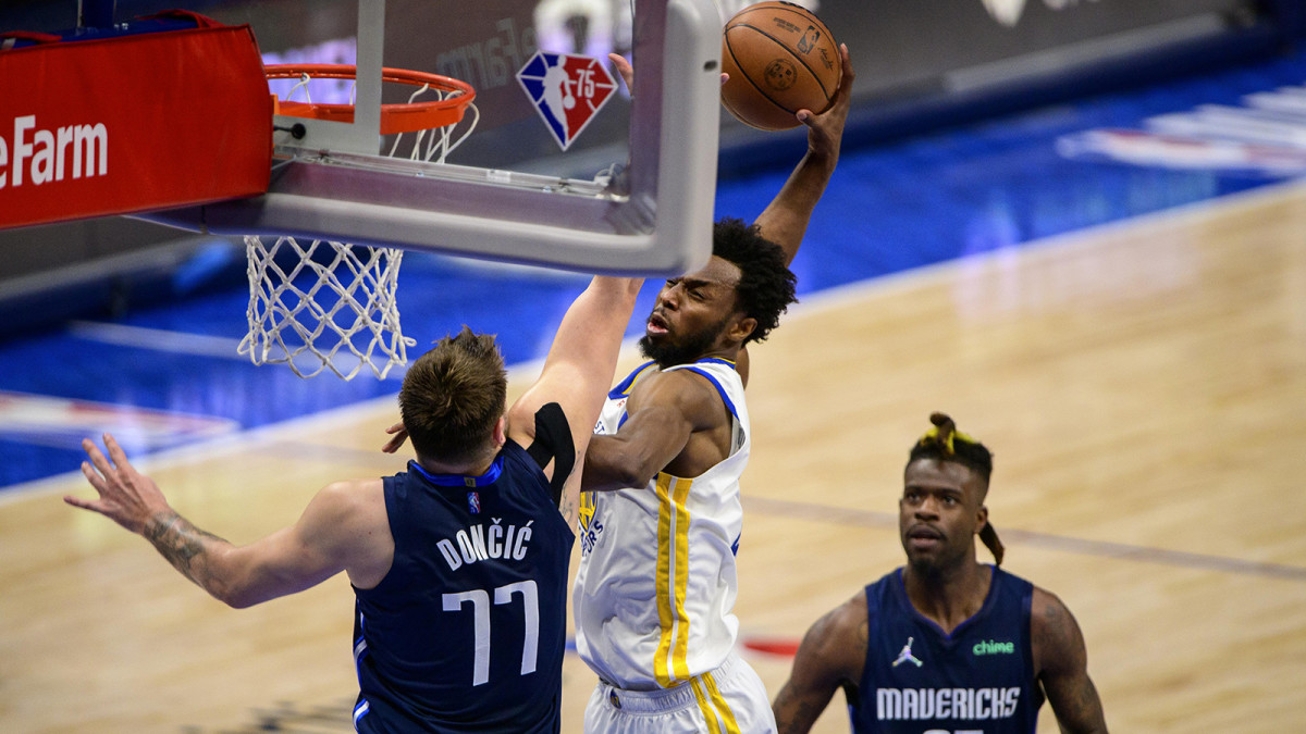 Golden State Warriors forward Andrew Wiggins (22) dunks the ball over Dallas Mavericks guard Luka Doncic.