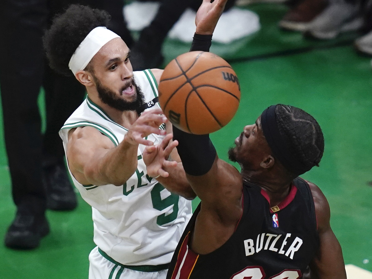 Boston Celtics guard Derrick White (9) passes the ball while pressured by Miami Heat forward Jimmy Butler (22) during the first half of Game 4 of the NBA basketball playoffs Eastern Conference finals, Monday, May 23, 2022, in Boston.