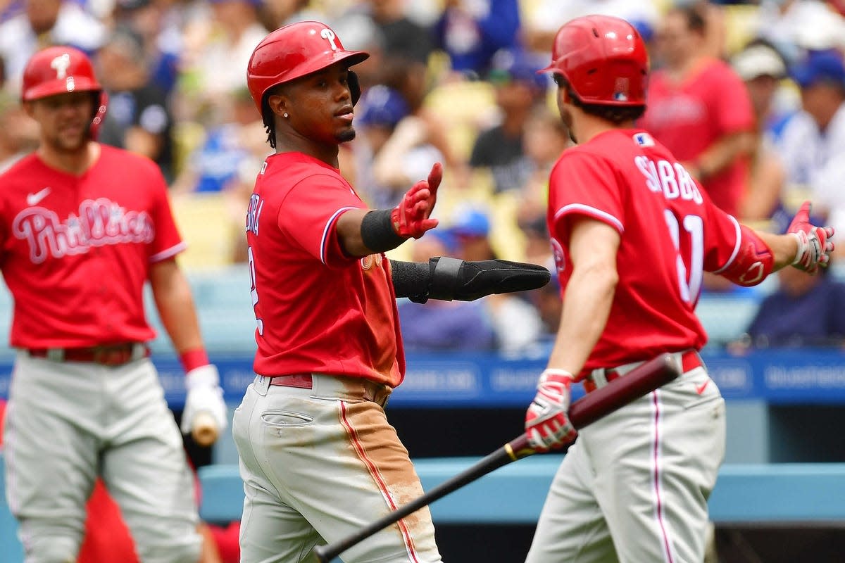 May 15, 2022; Los Angeles, California, USA; Philadelphia Phillies second baseman Jean Segura (2) is greeted by catcher Garrett Stubbs (21) after scoring a run against the Los Angeles Dodgers during the second inning at Dodger Stadium. Mandatory Credit: Gary A. Vasquez-USA TODAY Sports