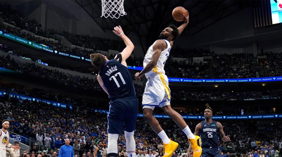 Golden State Warriors forward Andrew Wiggins (22) dunks the ball over Dallas Mavericks guard Luka Doncic (77) during the second half of Game 3 of the NBA basketball playoffs Western Conference finals, Sunday, May 22, 2022, in Dallas.
