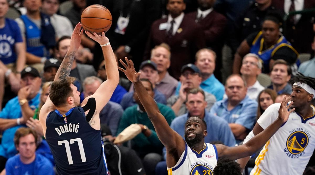 Dallas Mavericks guard Luka Doncic (77) shoots over Golden State Warriors forward Draymond Green (23) during the second half of Game 3 of the NBA basketball playoffs Western Conference finals, Sunday, May 22, 2022, in Dallas.
