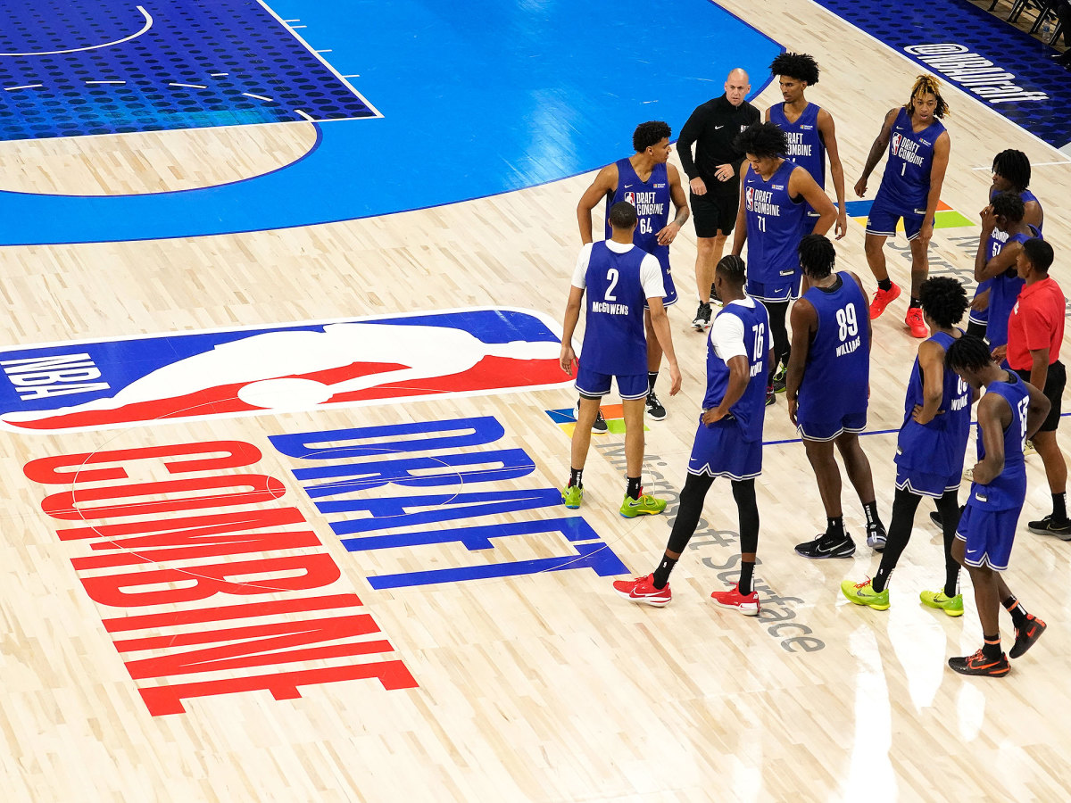 Players stand next to the NBA draft combine logo