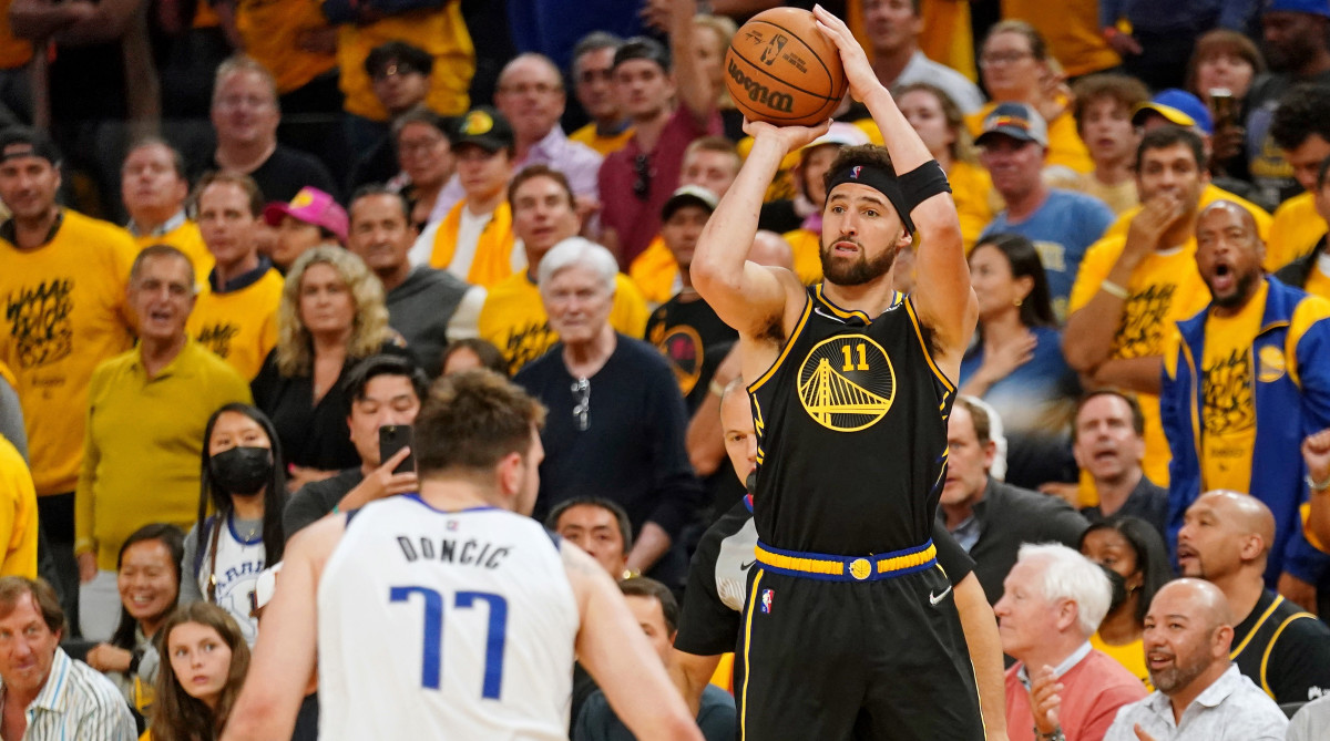 Warriors’ Klay Thompson shoots in front of Mavs’ Luka Doncic.