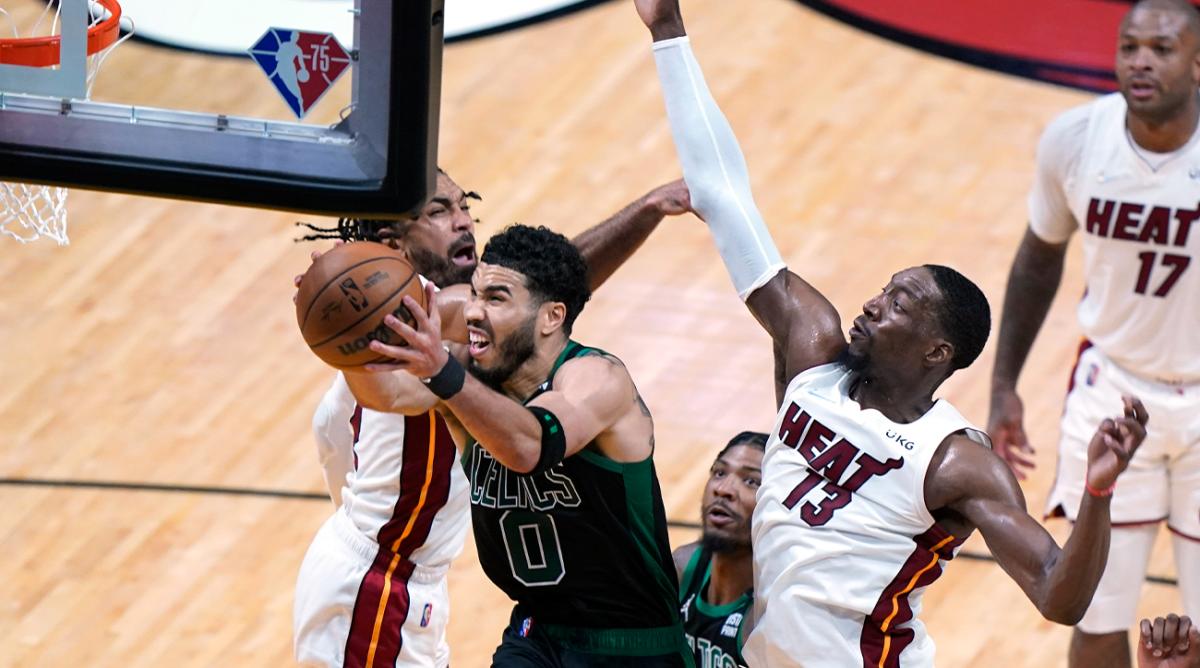 Boston Celtics forward Jayson Tatum (0) drives to the basket as Miami Heat center Bam Adebayo (13) and guard Gabe Vincent (2) defend during the second half of Game 5 of the NBA basketball Eastern Conference finals playoff series, Wednesday, May 25, 2022, in Miami.