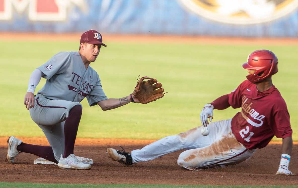 Alabama outfielder Andrew Pinckney (21) slides safely into second base as Texas A&M infielder Kole Kaler (1) fumbles the ball as Alabama Crimson Tide takes on Texas A&M Aggies during the SEC baseball tournament at the Hoover Metropolitan Stadium in Hoover, Ala., on Friday, May 27, 2022.