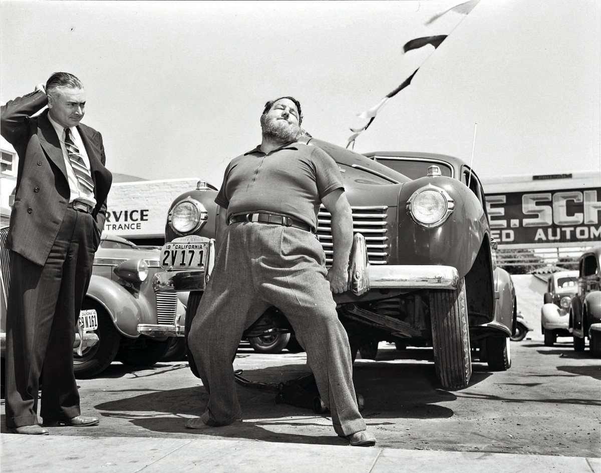 Leavitt lifting a car in an L.A. sales lot.