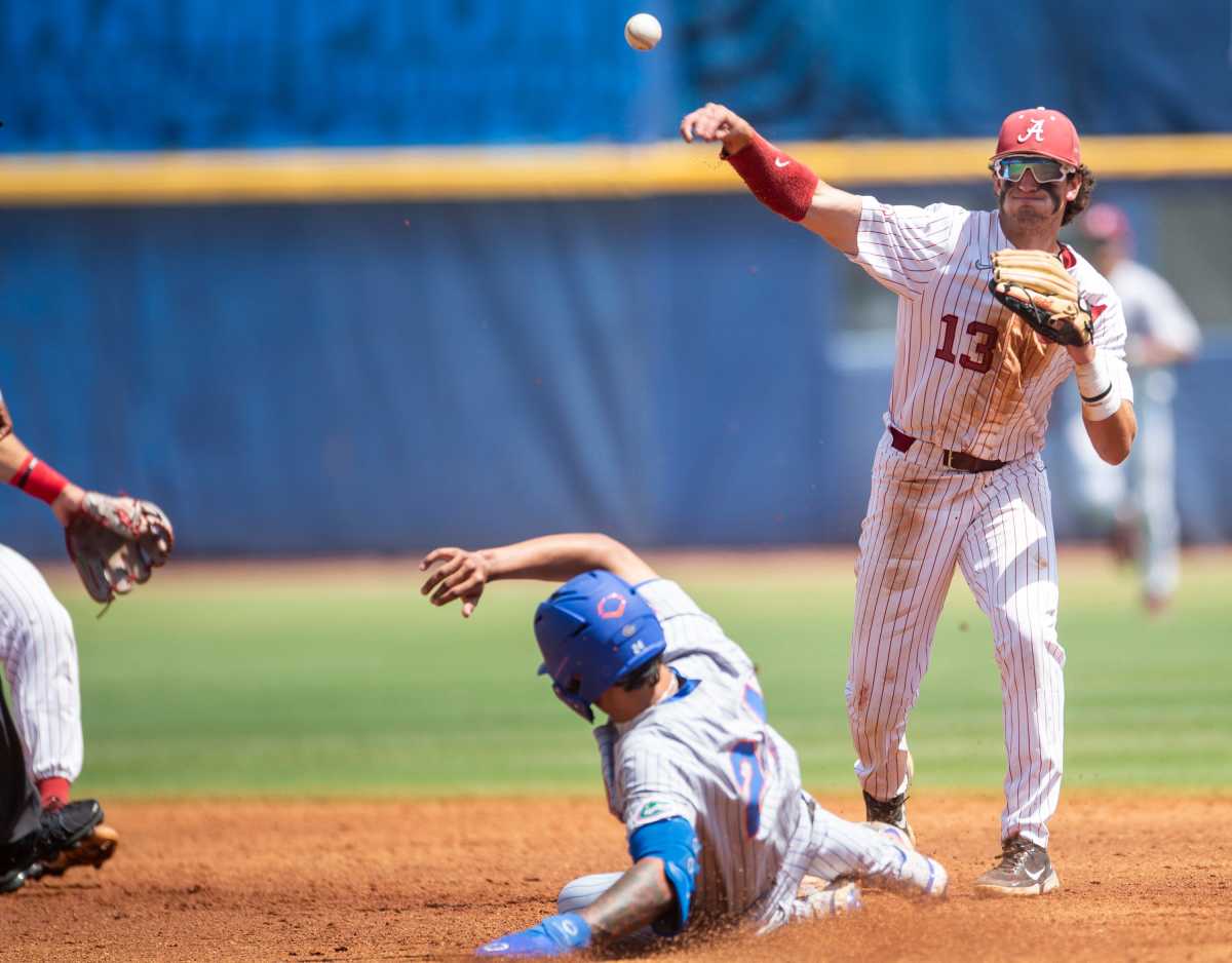 Alabama infielder Bryce Eblin (13) turns a double play as Alabama Crimson Tide take on Florida Gators during the SEC baseball tournament at the Hoover Metropolitan Stadium in Hoover, Ala., on Saturday, May 28, 2022.