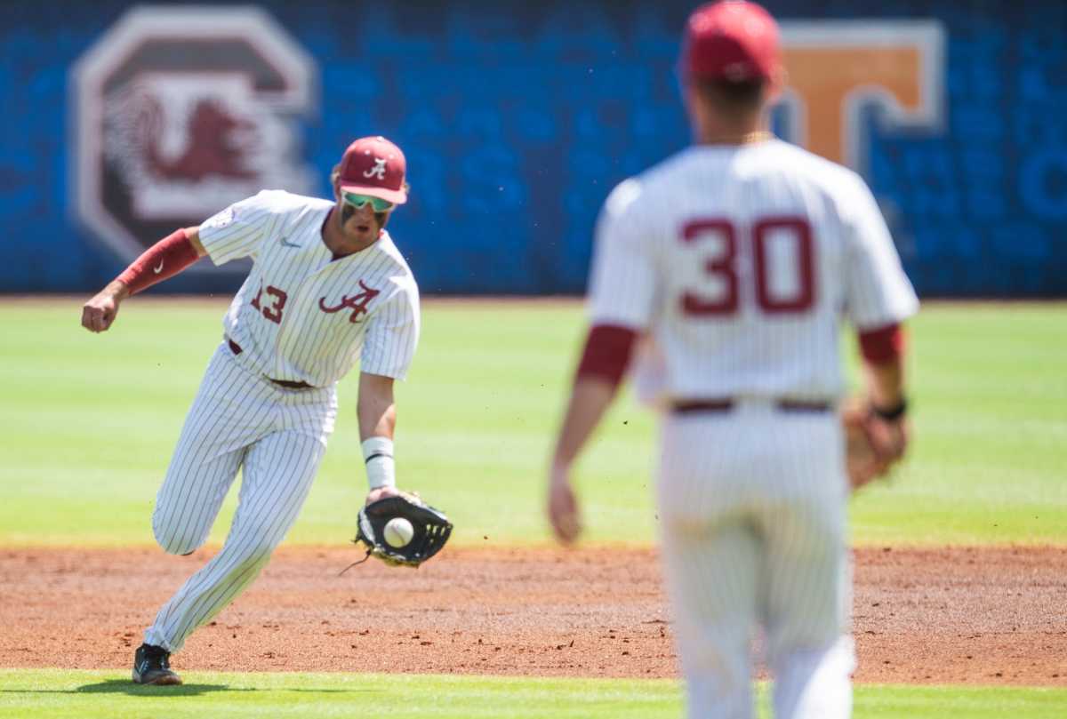 Alabama infielder Bryce Eblin (13) scoops up a ground ball as Alabama Crimson Tide take on Florida Gators during the SEC baseball tournament at the Hoover Metropolitan Stadium in Hoover, Ala., on Saturday, May 28, 2022.