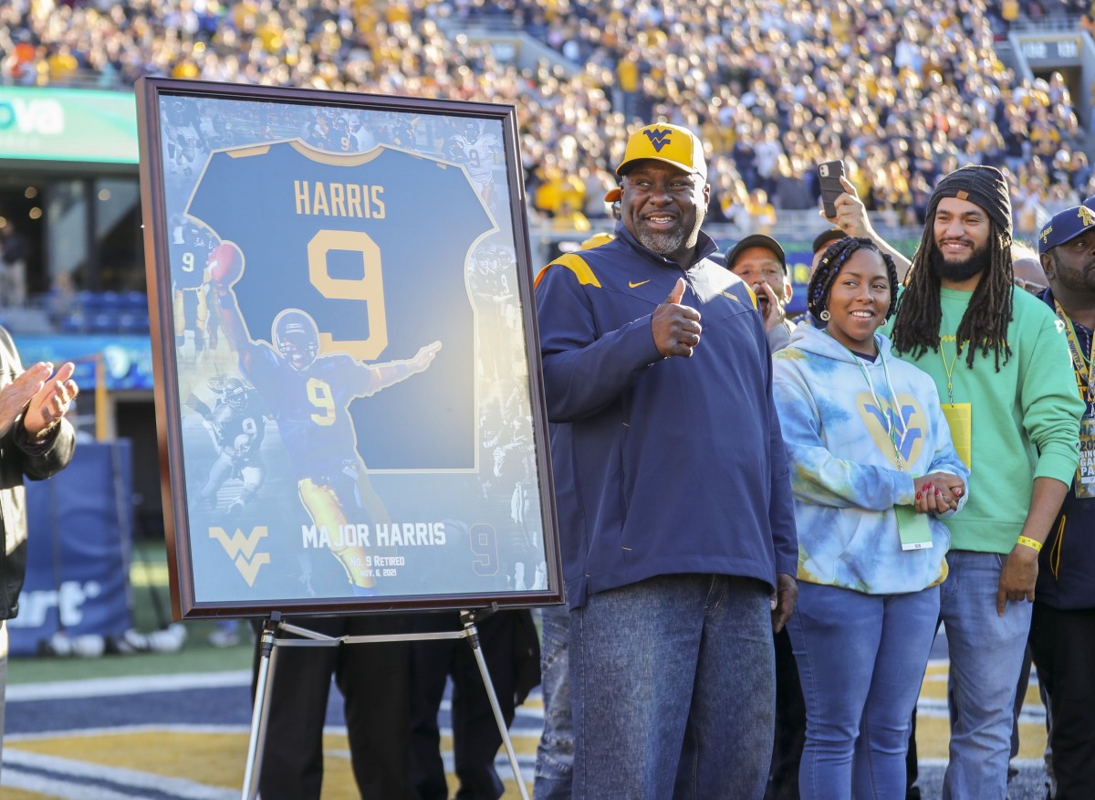 Nov 6, 2021; Morgantown, West Virginia, USA; Former West Virginia Mountaineers player Major Harris waves to the crowd during a ceremony to retire his No. 9 after the first quarter against the Oklahoma State Cowboys at Mountaineer Field at Milan Puskar Stadium.
