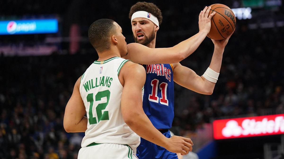 Golden State Warriors guard Klay Thompson (11) holds onto the ball next to Boston Celtics forward Grant Williams.