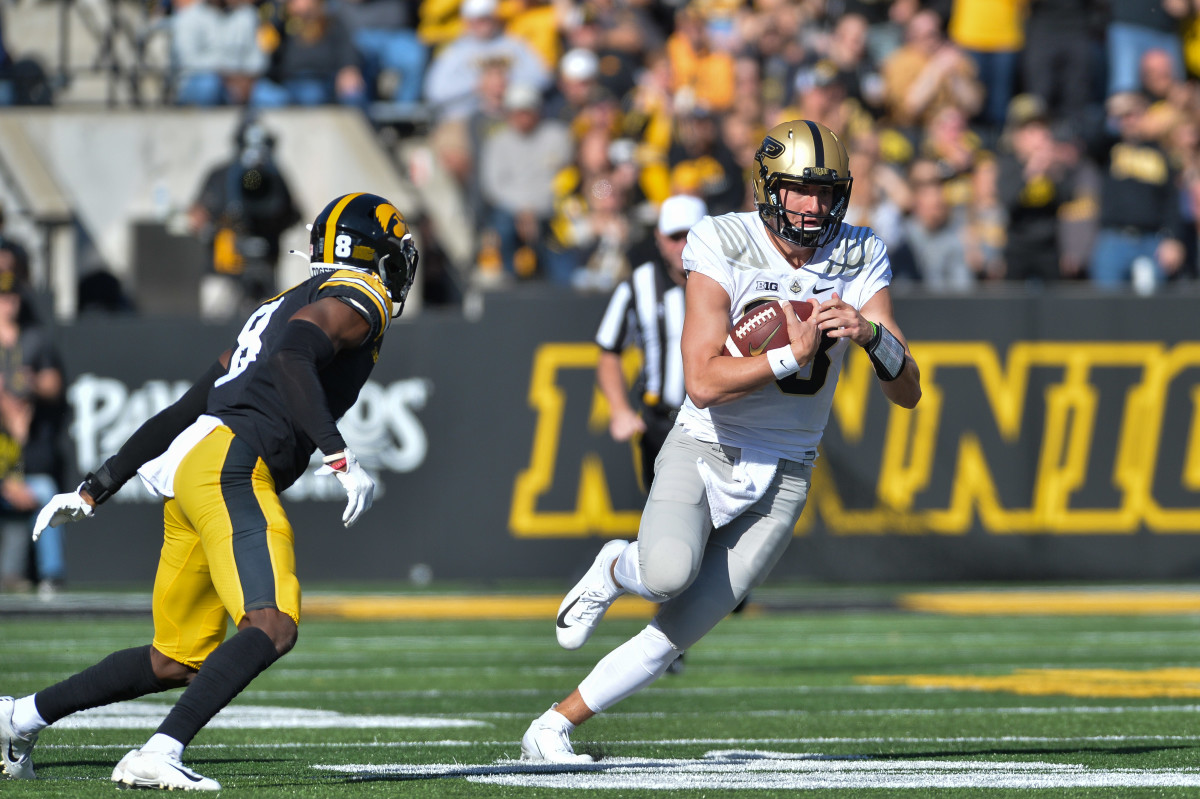 Purdue Boilermakers quarterback Jack Plummer (13) runs the ball while being pursued by Iowa Hawkeyes defensive back Matt Hankins (8) during the first quarter at Kinnick Stadium.