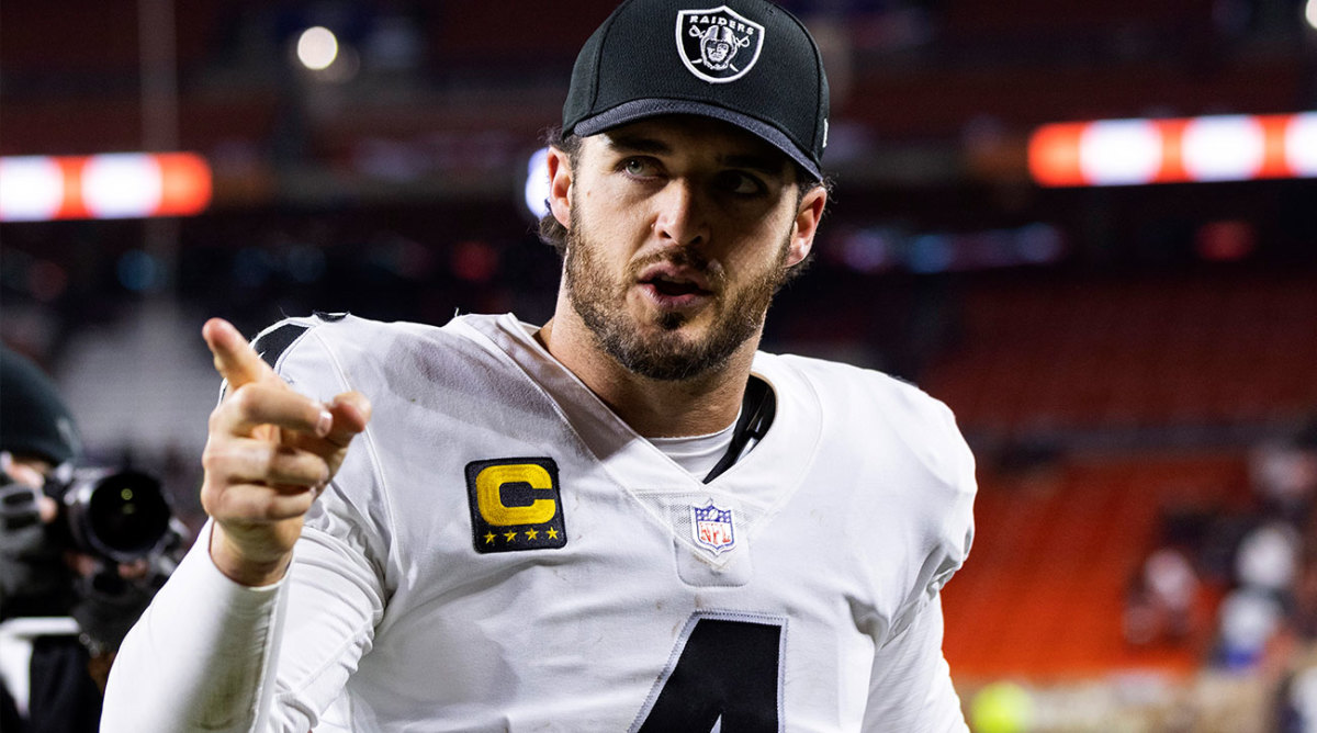 Derek Carr points to the stands wearing a Raiders hat.