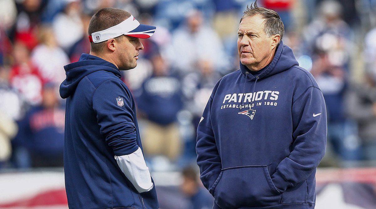 Josh McDaniels talks to Bill Belichick, both wearing Patriots gear.