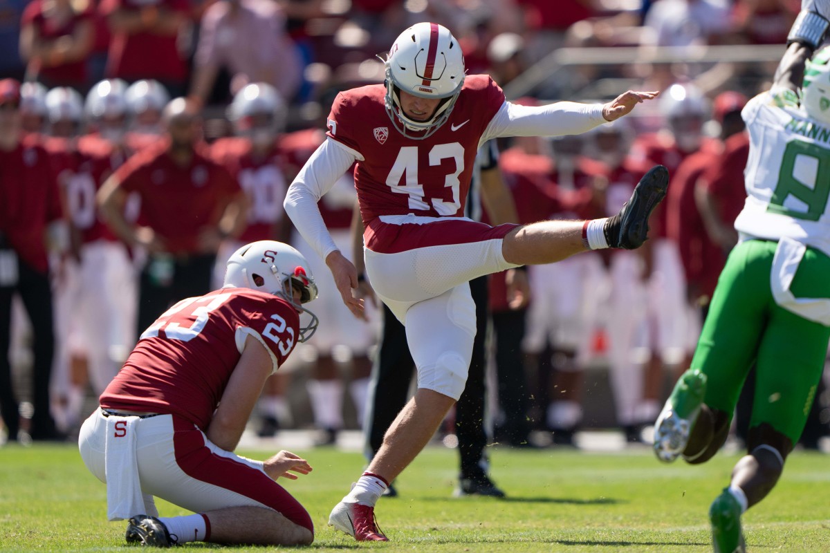 Stanford Cardinal punter Ryan Sanborn (23) holds the ball for place kicker Joshua Karty (43) during the first quarter against the Oregon Ducks at Stanford Stadium.