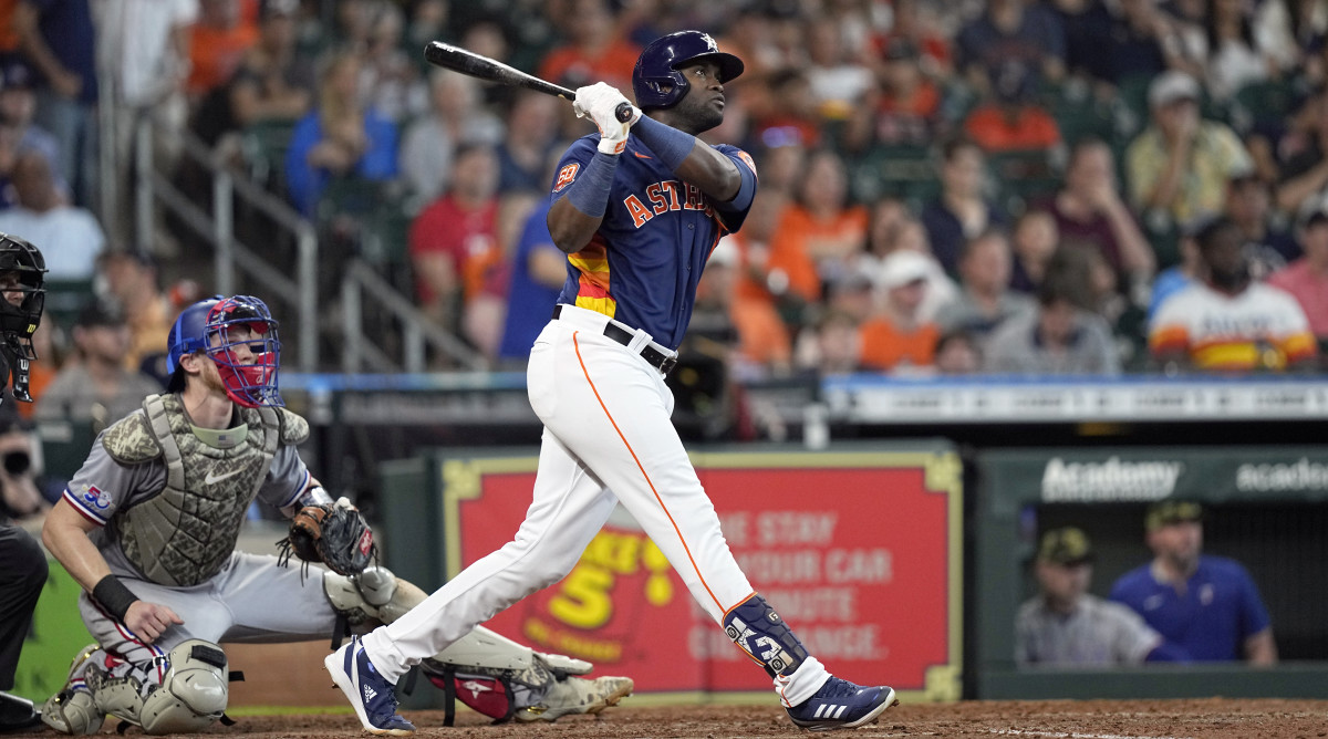 Houston Astros’ Yordan Alvarez, right, hits an RBI-double as Texas Rangers catcher Sam Huff watches during the fifth inning of a baseball game Sunday, May 22, 2022, in Houston.