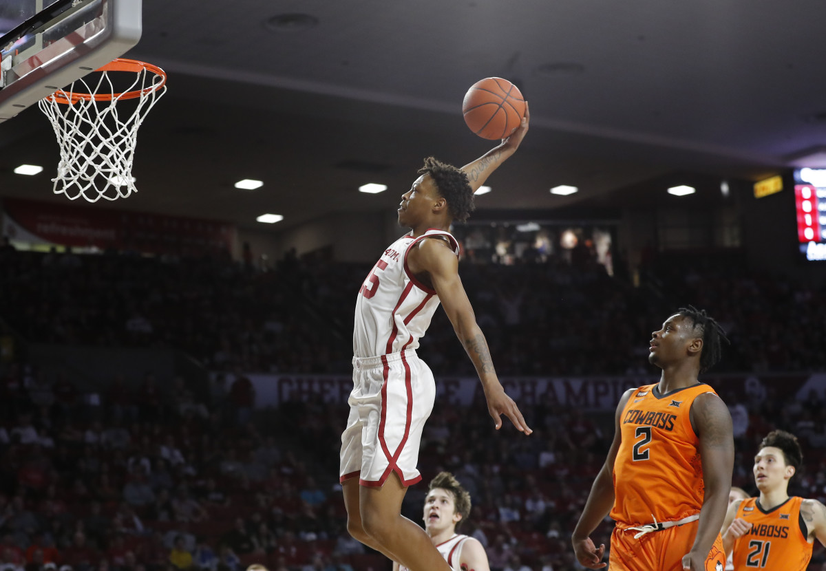Oklahoma Sooners guard Alondes Williams (15) dunks as Oklahoma State Cowboys guard Chris Harris Jr. (2) looks on during the first half at Lloyd Noble Center.
