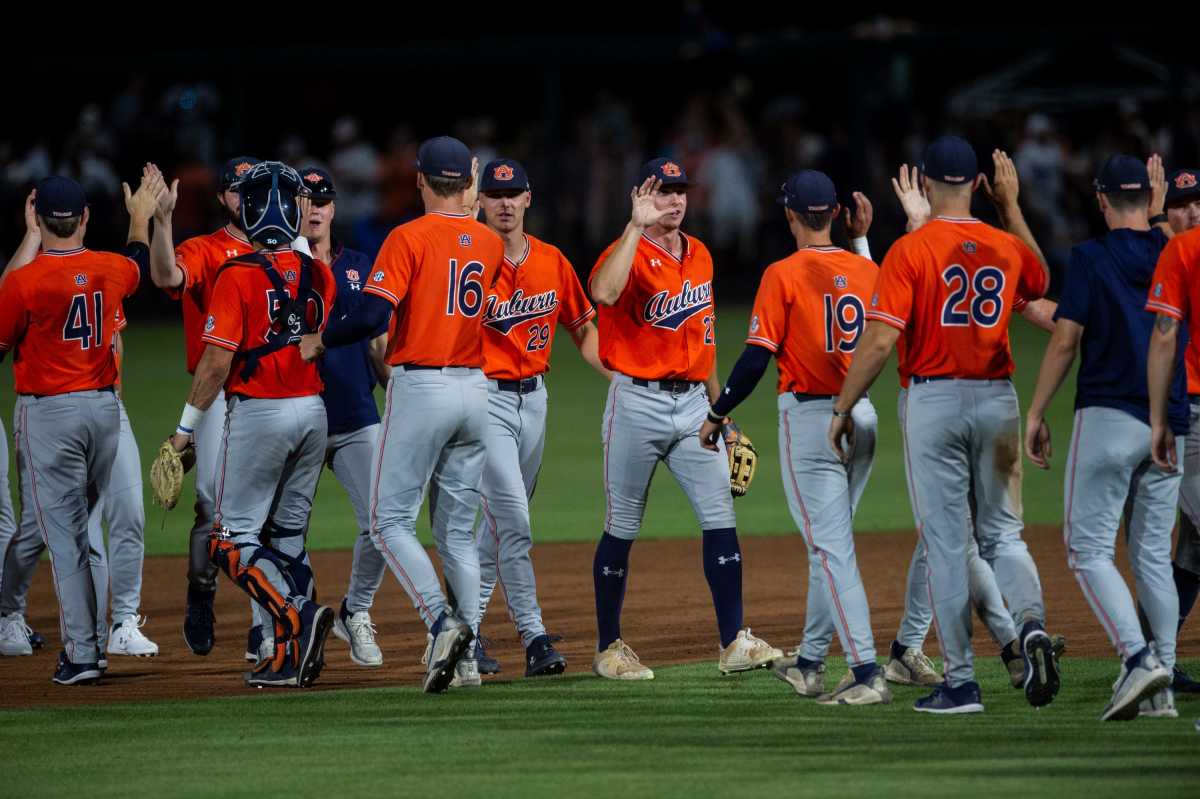 Auburn Tigers baseball players Cam Hill (16), Brooks Carlson (19), Nate LaRue (28), Carson Skipper (29), John Armstrong (41) and teammates high five after the game against Florida State in the NCAA regional baseball tournament at Plainsman Park in Auburn, Alabama, on Saturday, June 4, 2022. Auburn defeated Florida State 21-7.
