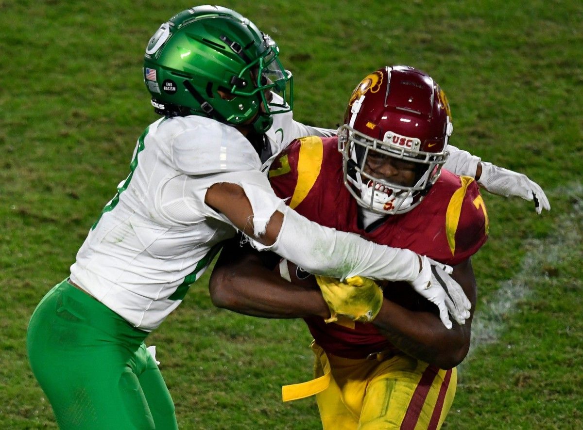 Oregon Ducks cornerback Deommodore Lenoir (0) tackles USC Trojans running back Stephen Carr (7) during the fourth quarter at United Airlines Field at Los Angeles Memorial Coliseum.