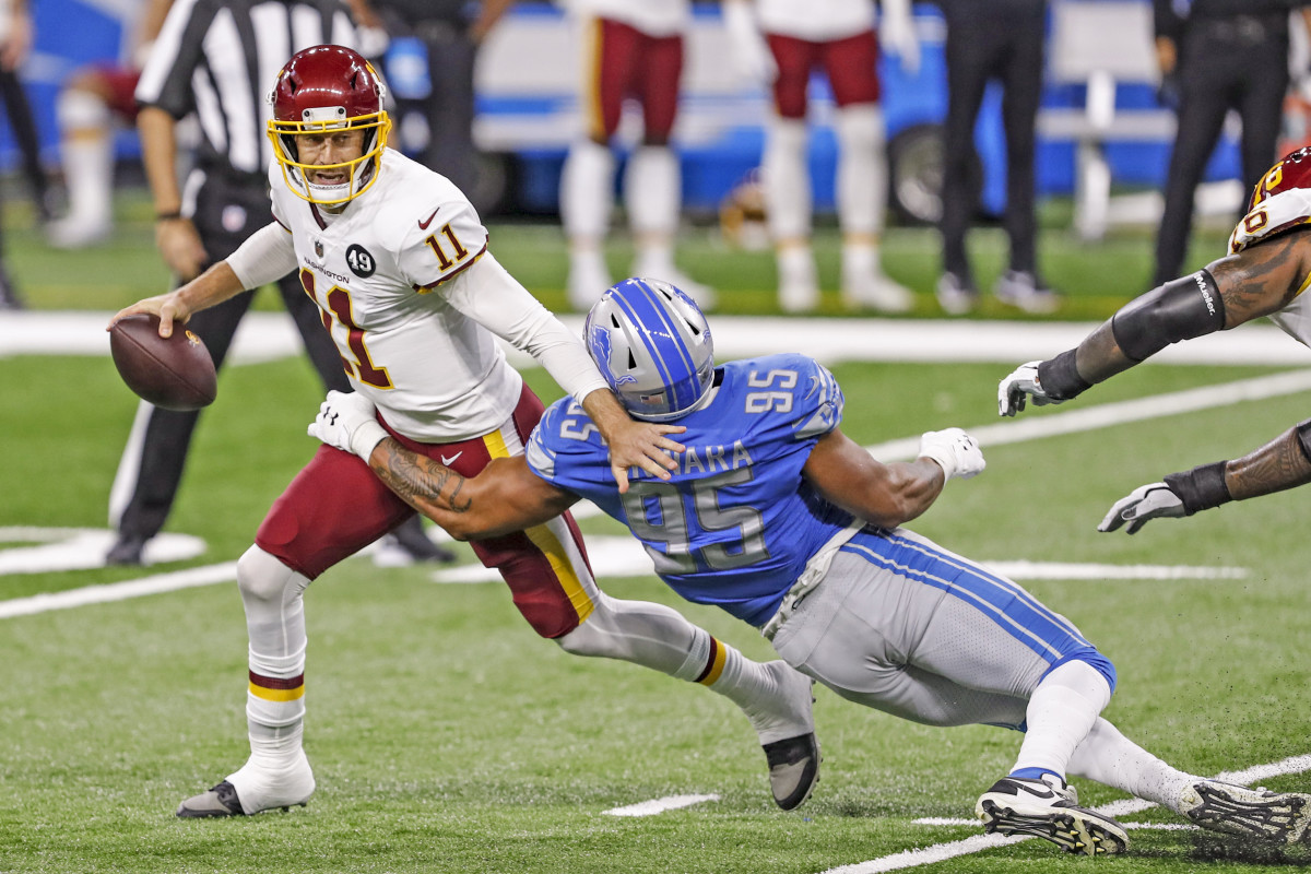 Alex Smith avoids a sack during a 2020 game against the Lions, his first start since his injury