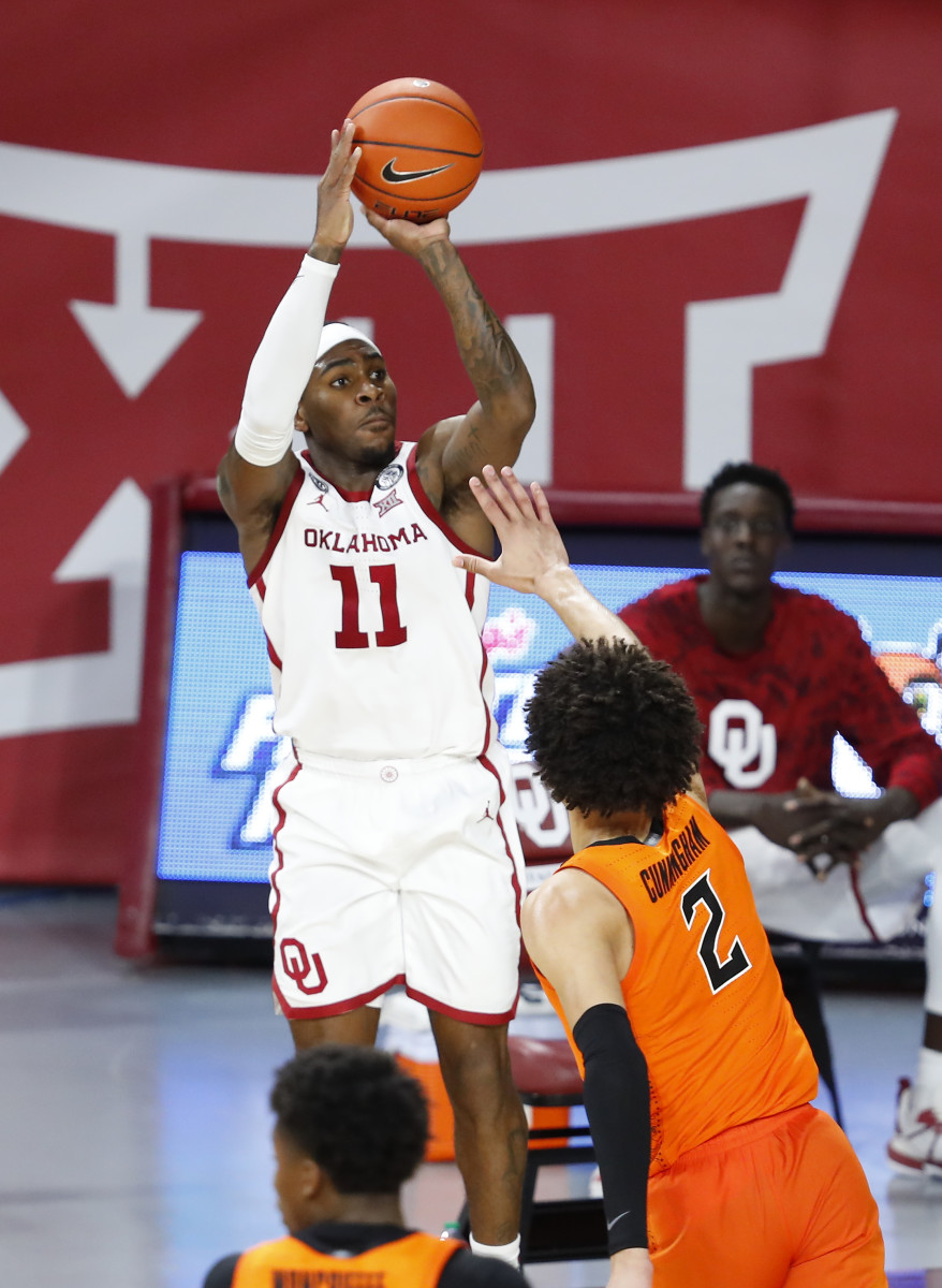 De'Vion Harmon (11) shoots over potential No. 1 overall 2021 NBA Draft Pick Cade Cunningham (2) on February 27, 2021 at the Lloyd Noble Center in Norman, Oklahoma. 