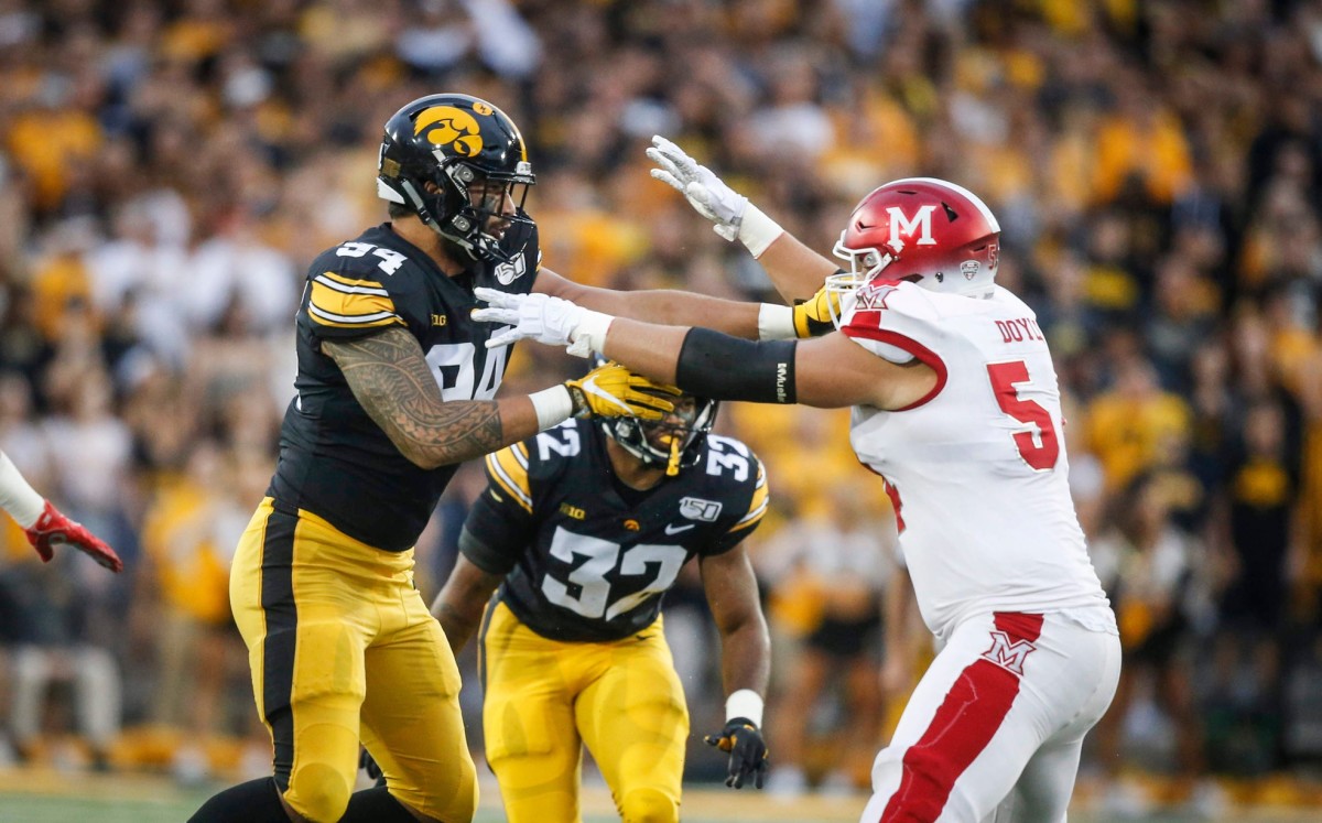 Iowa junior defensive end A.J. Epenesa, left, shoves Miami of Ohio offensive lineman Tommy Doyle in the first quarter at Kinnick Stadium in Iowa City on Saturday, Aug. 31, 2019.