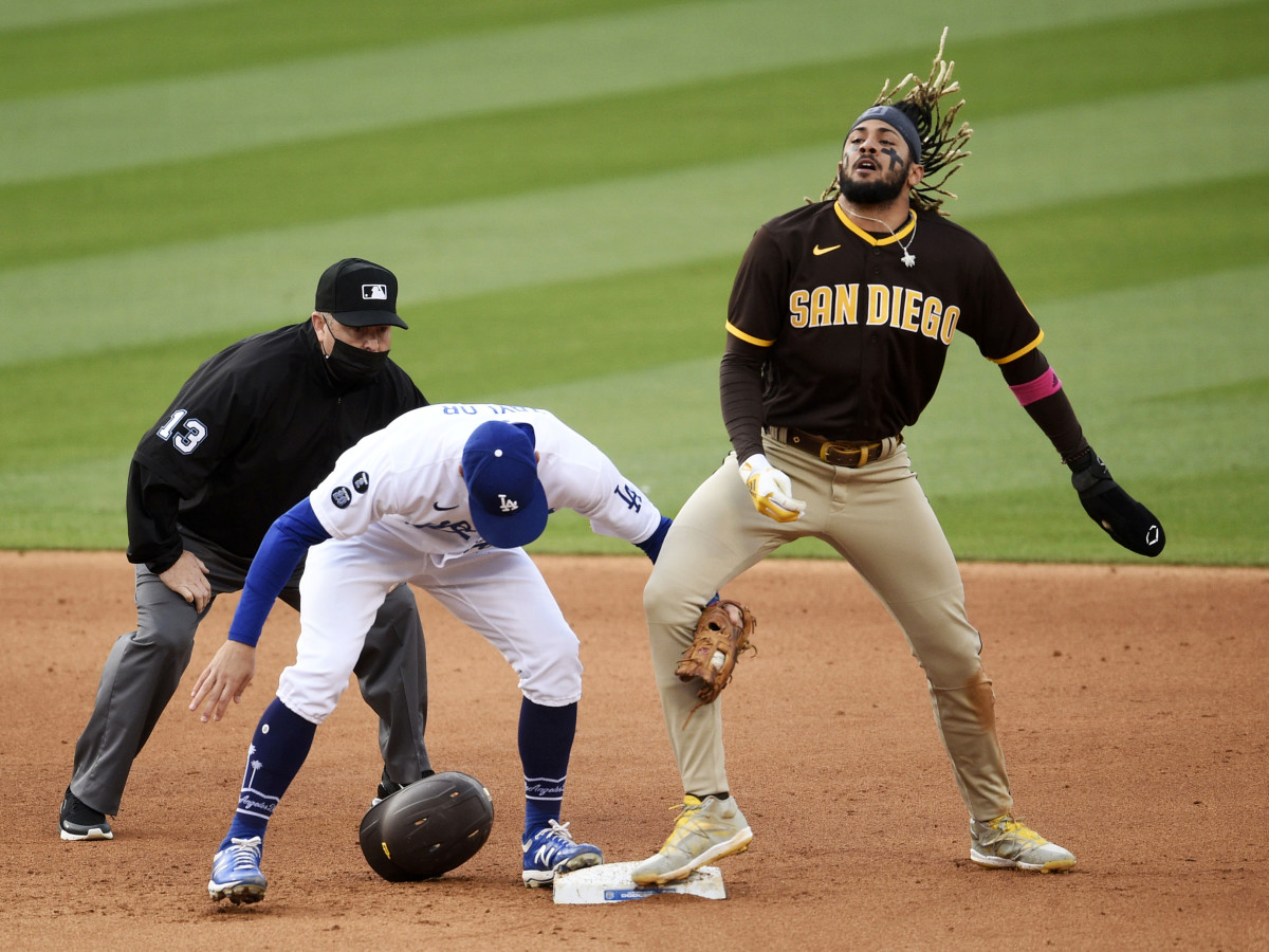 Apr 25, 2021; Los Angeles, California, USA; San Diego Padres shortstop Fernando Tatis Jr. (23) tosses his hair after stealing second base against Los Angeles Dodgers second baseman Chris Taylor (3)during the sixth inning at Dodger Stadium.