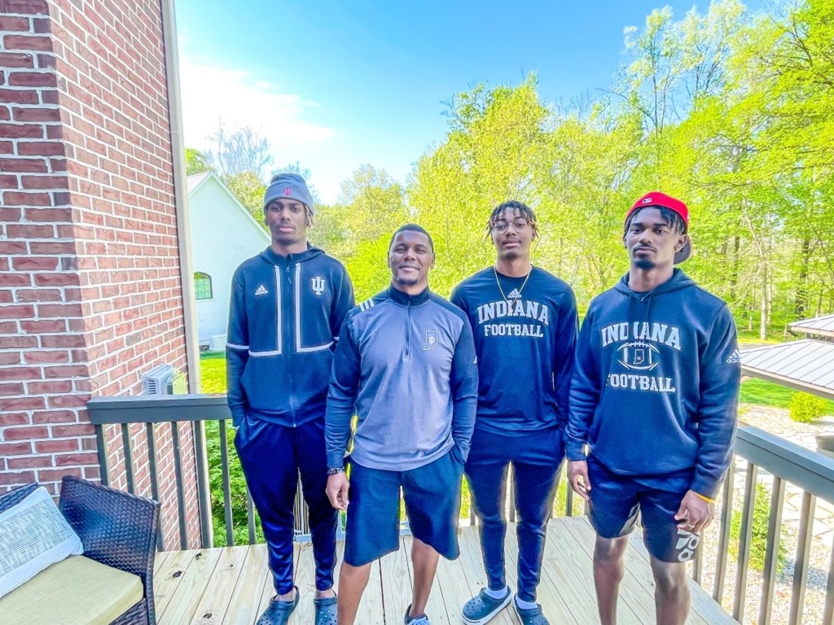 Indiana running backs and assistant head coach Deland McCullough poses on his porch with his three sons, who all committed to Indiana in the past two weeks.