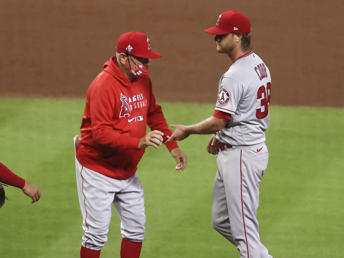 Los Angeles Angels manager Joe Maddon (right) gives the ball to relief pitcher Alex Claudio (58) in the sixth inning against the Texas Rangers at Angel Stadium.