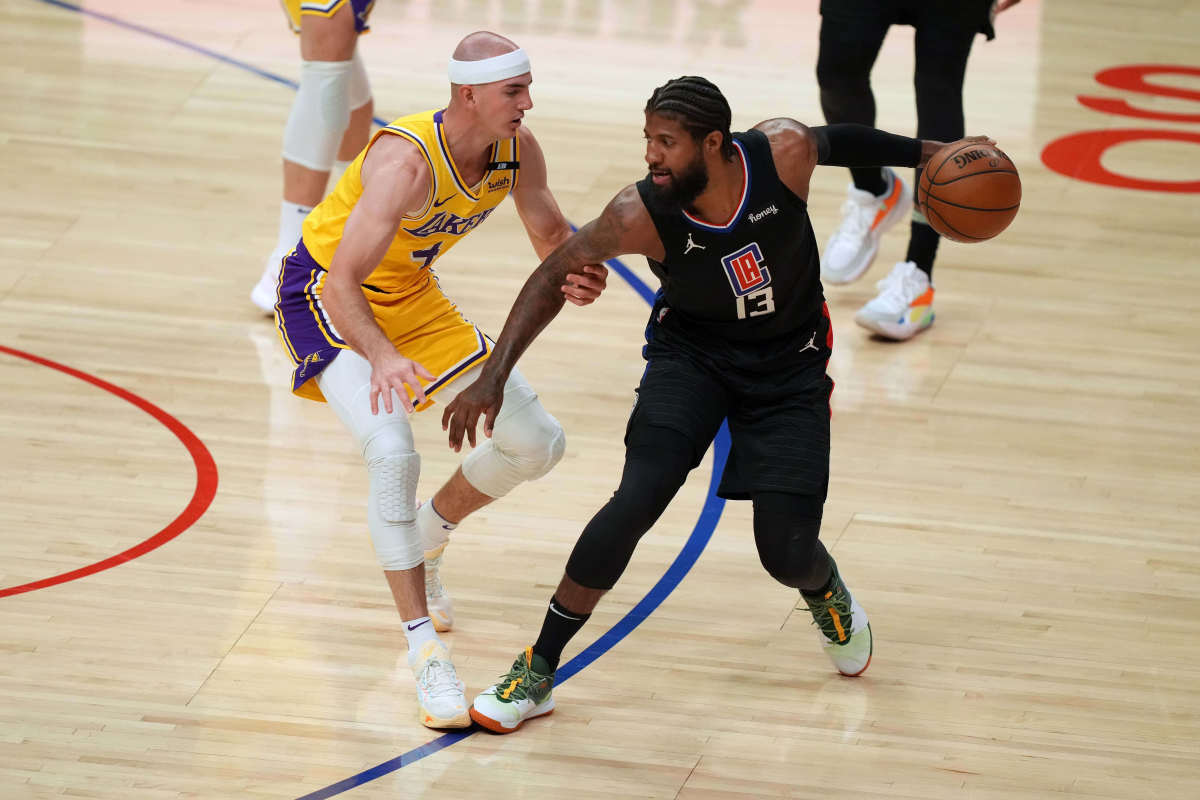 May 6, 2021; Los Angeles, California, USA; LA Clippers guard Paul George (13) handles the ball while defended by Los Angeles Lakers guard Alex Caruso (4) in the first half at Staples Center. Mandatory Credit: Kirby Lee-USA TODAY Sports