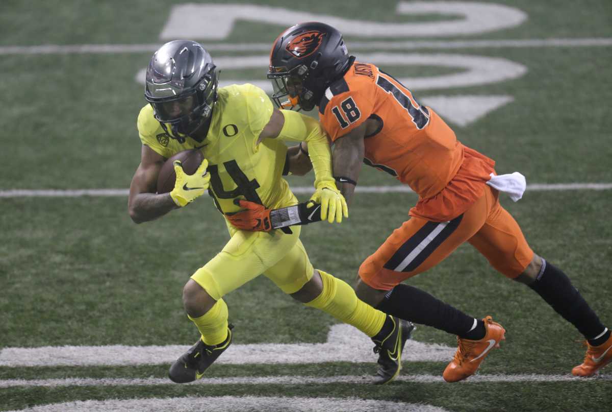 Kris Hutson (14) fights for extra yards against Oregon State's Alex Austin (18) at Reser Stadium. 