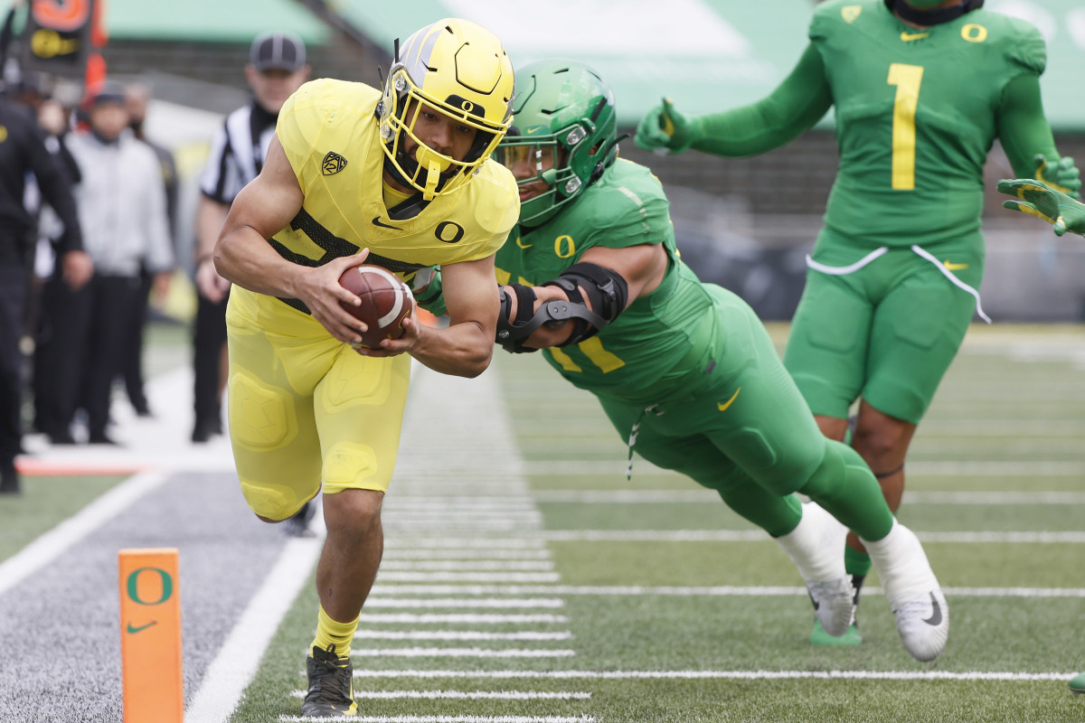 Travis Dye dives for the end zone as Isaac Slade-Matautia (41) tries to bring him down in Oregon's 2021 spring football game.