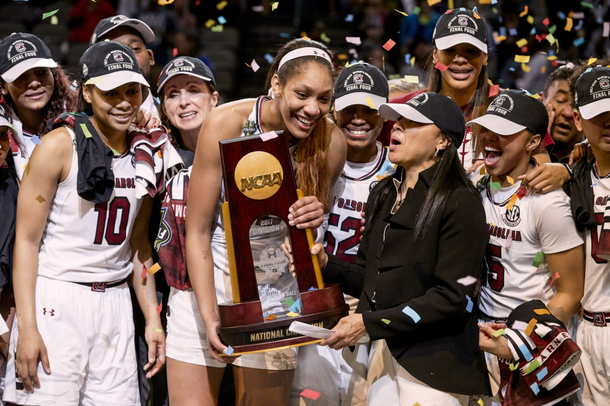 Dawn Staley holds the NCAA trophy with A'ja Wilson and her teammates