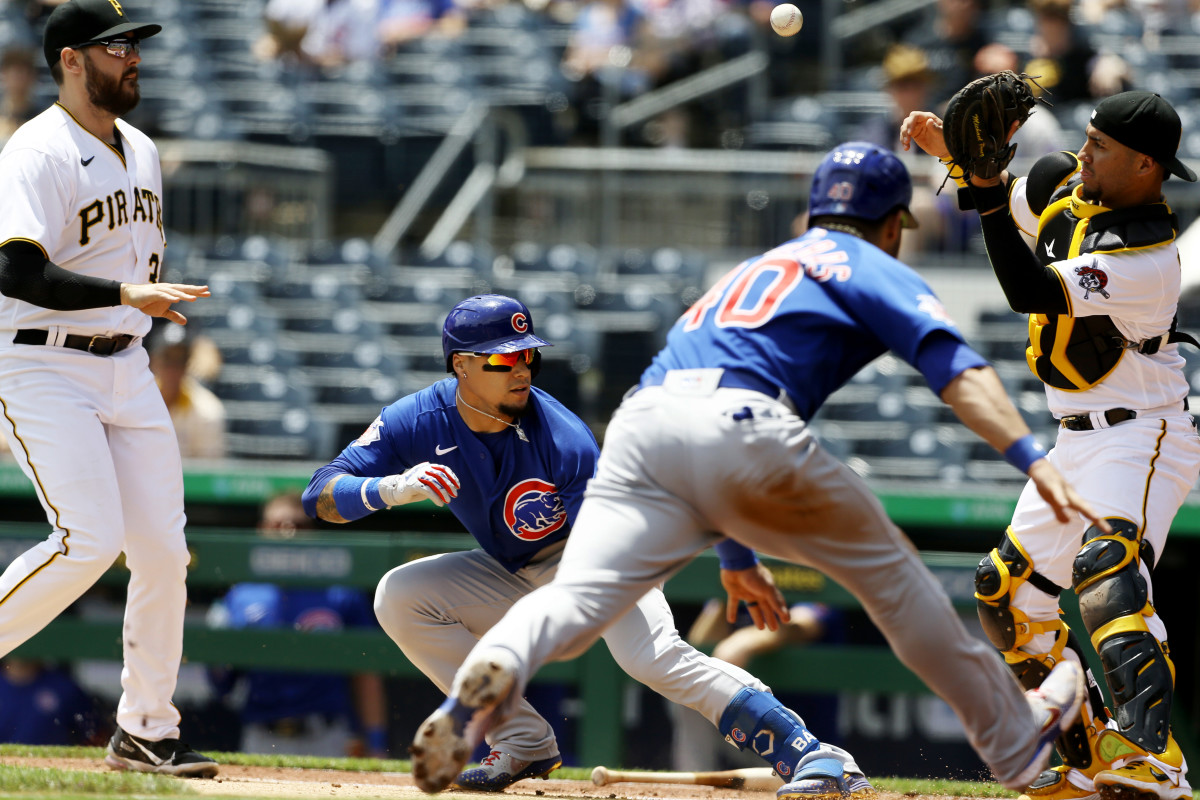 May 27, 2021; Pittsburgh, Pennsylvania, USA;  Pittsburgh Pirates first baseman Will Craig (left) chases Chicago Cubs shortstop Javier Baez (9) in a run-down between home plate and first base allowing catcher Willson Contreras (40) to score a run as Pirates catcher Michael Perez (right) takes a throw during the third inning at PNC Park.