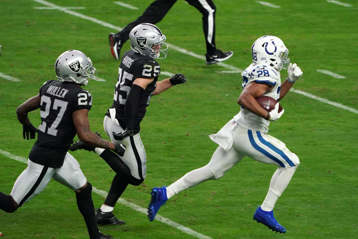 Dec 13, 2020; Paradise, Nevada, USA; Indianapolis Colts running back Jonathan Taylor (28) runs with the ball for a touchdown while pursued by Las Vegas Raiders free safety Erik Harris (25) and cornerback Trayvon Mullen (27) in the third quarter at Allegiant Stadium.