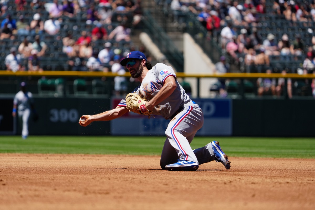 Jun 3, 2021; Denver, Colorado, USA; Texas Rangers first baseman Charlie Culberson (2) fields the ball in the second inning against the Colorado Rockies at Coors Field.
