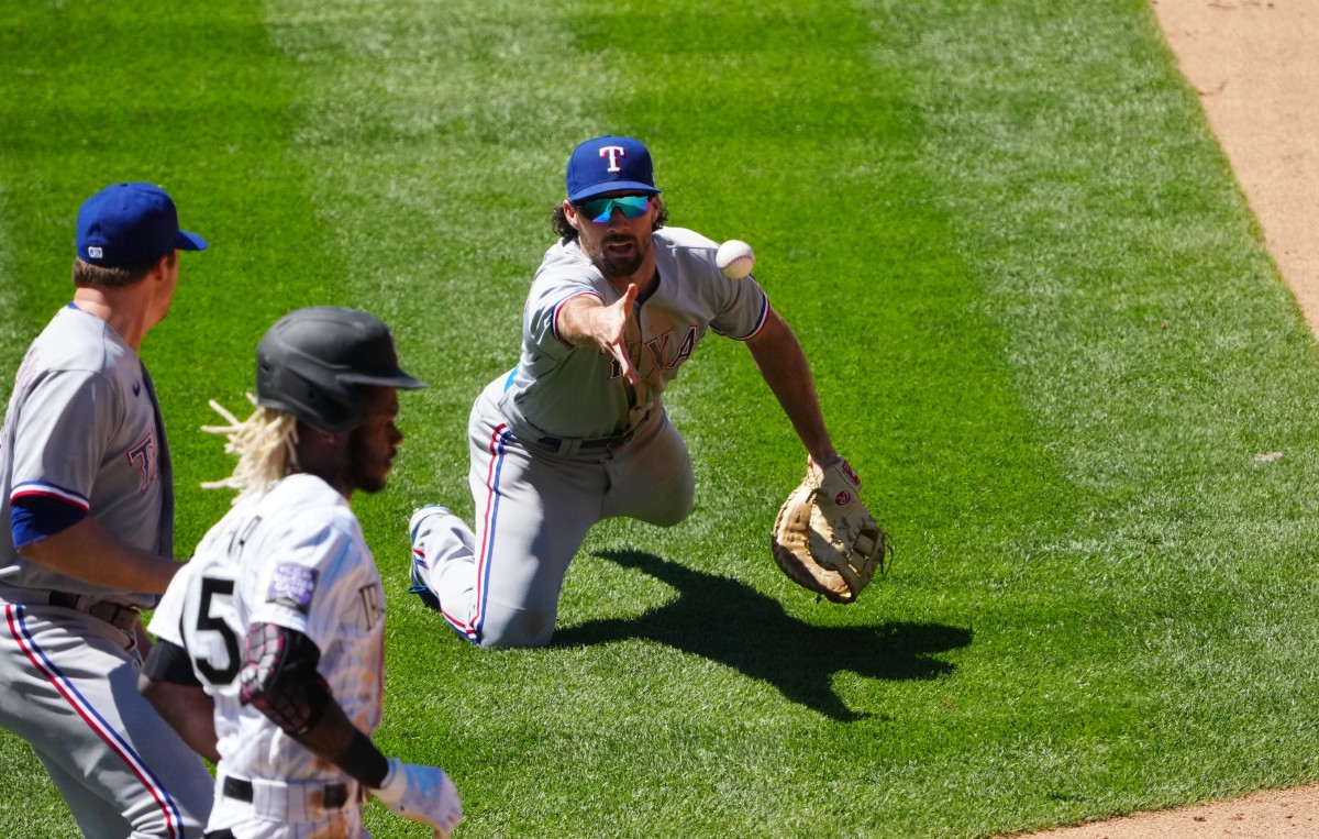 Jun 3, 2021; Denver, Colorado, USA; Texas Rangers infielder Charlie Culberson (2) fields the ball at relief pitcher Wes Benjamin (63) in the fifth inning against the Colorado Rockies at Coors Field.