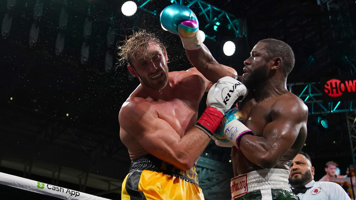 Floyd Mayweather Jr. (Green Trunks) fights Logan Paul (Yellow Trunks) during an exhibition boxing match at Hard Rock Stadium.