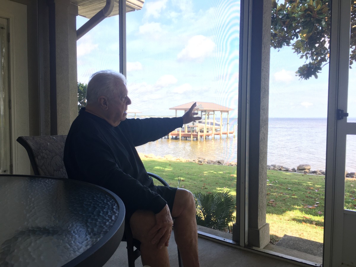 Pete Jenkins, a longtime SEC defensive line coach, gestures toward the bay from his home near the 30A area.