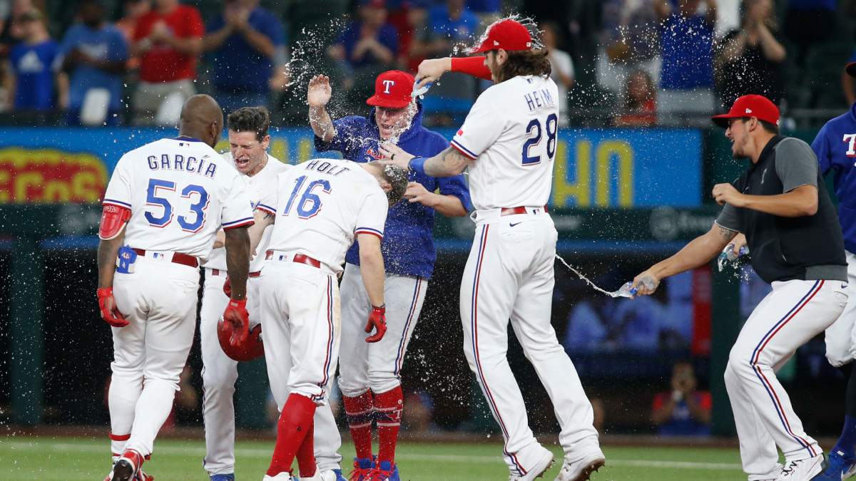 Jun 9, 2021; Arlington, Texas, USA; Texas Rangers third baseman Brock Holt (16) is congratulated by his teammates after driving in the winning run in the eleventh inning against the San Francisco Giants at Globe Life Field.