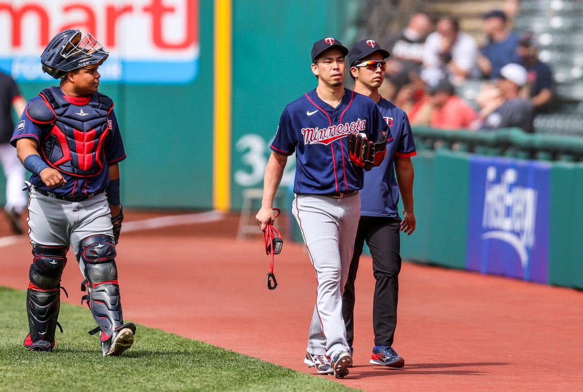 Twins righthander Kenta Maeda (center) walks catcher Willians Astudillo (left) and his interpreter Daichi Sekizaki.