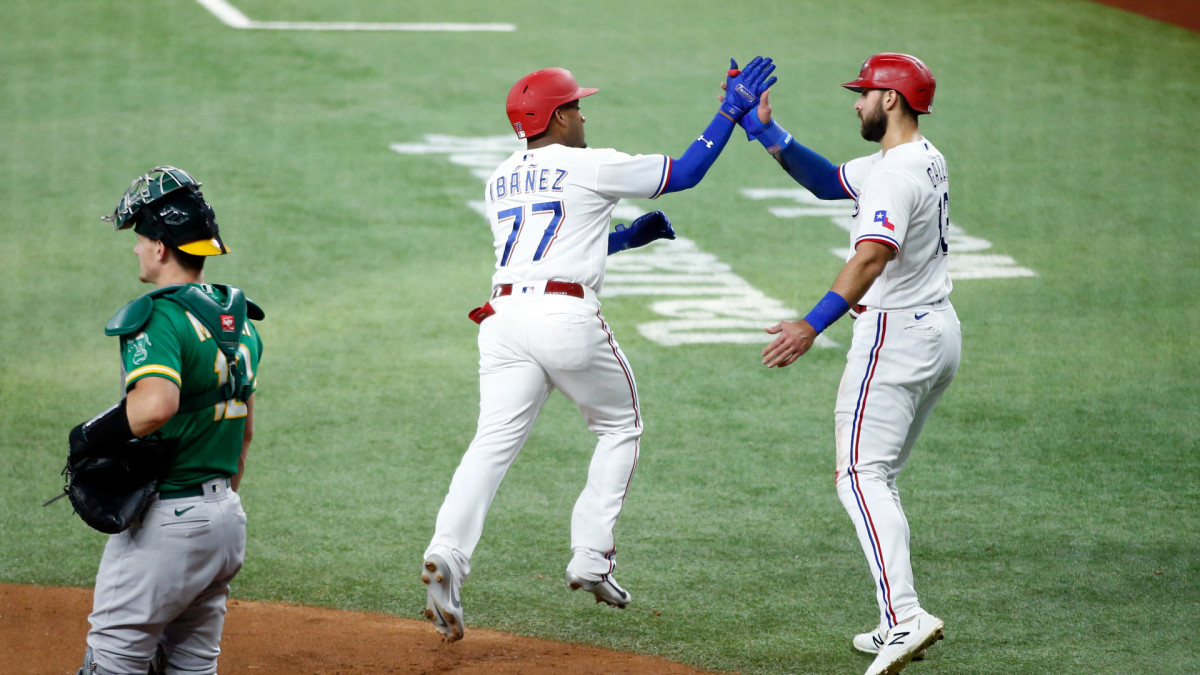 Jun 21, 2021; Arlington, Texas, USA; Texas Rangers second baseman Andy Ibanez (77) is congratulated by right fielder Joey Gallo (13) after hitting a three run home run in the first inning against the Oakland Athletics at Globe Life Field.