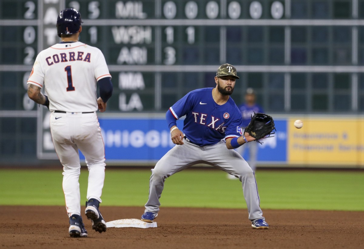 May 15, 2021; Houston, Texas, USA; Texas Rangers shortstop Isiah Kiner-Falefa (9) forces out Houston Astros shortstop Carlos Correa (1) at second base in the fifth inning at Minute Maid Park.