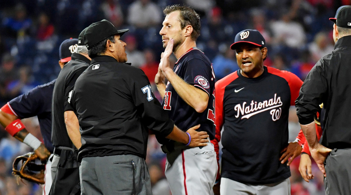 Jun 22, 2021; Philadelphia, Pennsylvania, USA; Washington Nationals  pitcher Max Scherzer (31) and manager Dave Martinez (4) talk with umpire Alfonso Marquez (72) as they check for a foreign substance on Scherzer during the middle of the fourth inning against the Philadelphia Phillies at Citizens Bank Park.