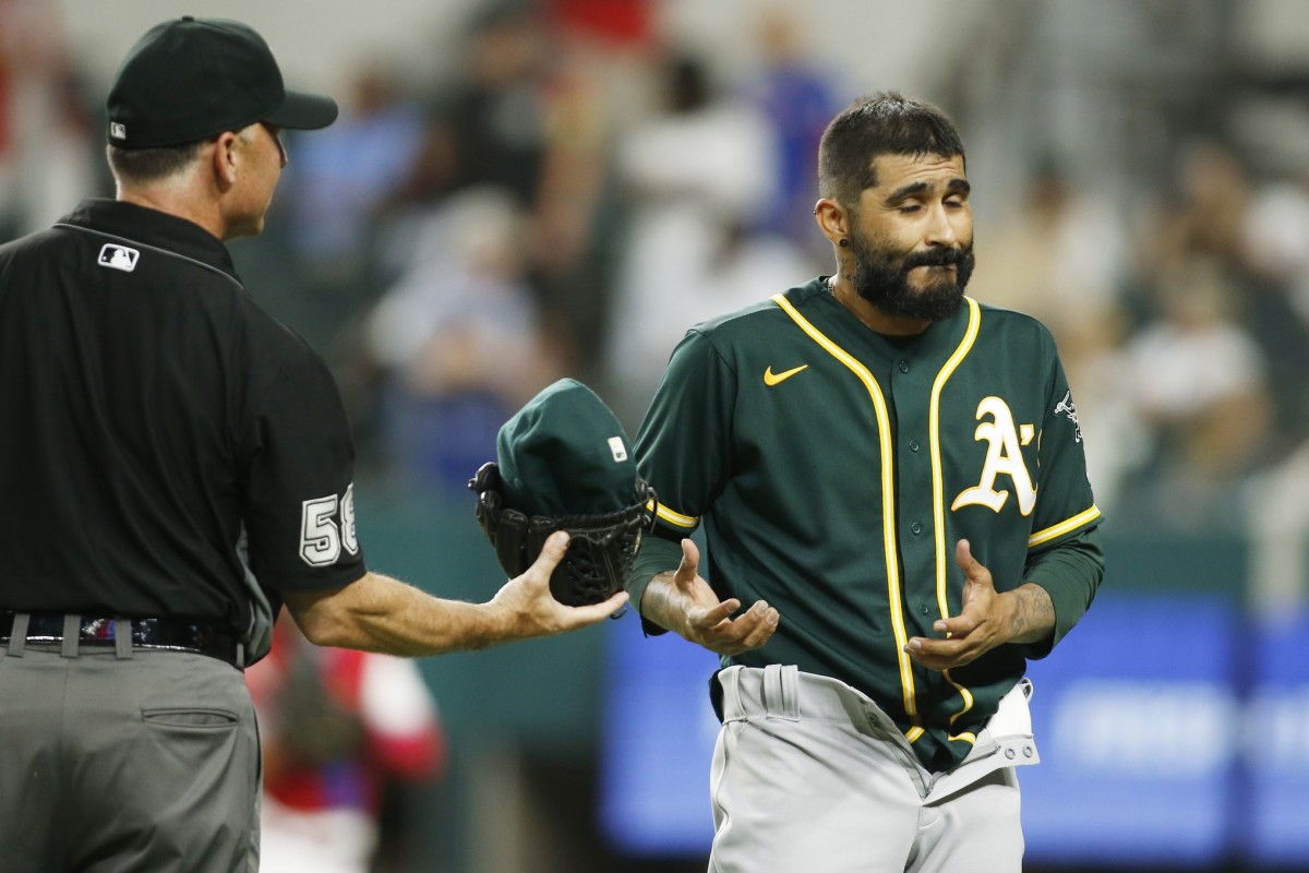 Jun 22, 2021; Arlington, Texas, USA; Oakland Athletics relief pitcher Sergio Romo (54) is checked for foreign substances by umpire Dan Iassogna (58)after the seventh inning against the Texas Rangers at Globe Life Field.