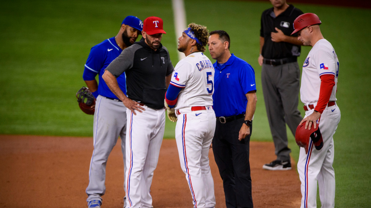 Jun 26, 2021; Arlington, Texas, USA; Texas Rangers manager Chris Woodward (8) checks on Rangers designated hitter Willie Calhoun (5) after Calhoun is hit by a pitch during the second inning against the Kansas City Royals at Globe Life Field.