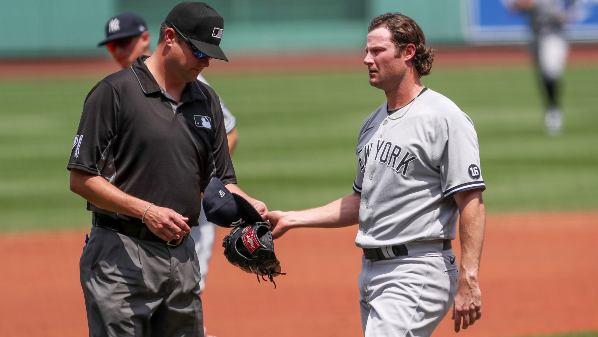 Jun 27, 2021; Boston, Massachusetts, USA; Umpires check  the hat and glove of New York Yankees starting pitcher Gerrit Cole (45) during the first inning against the Boston Red Sox at Fenway Park.