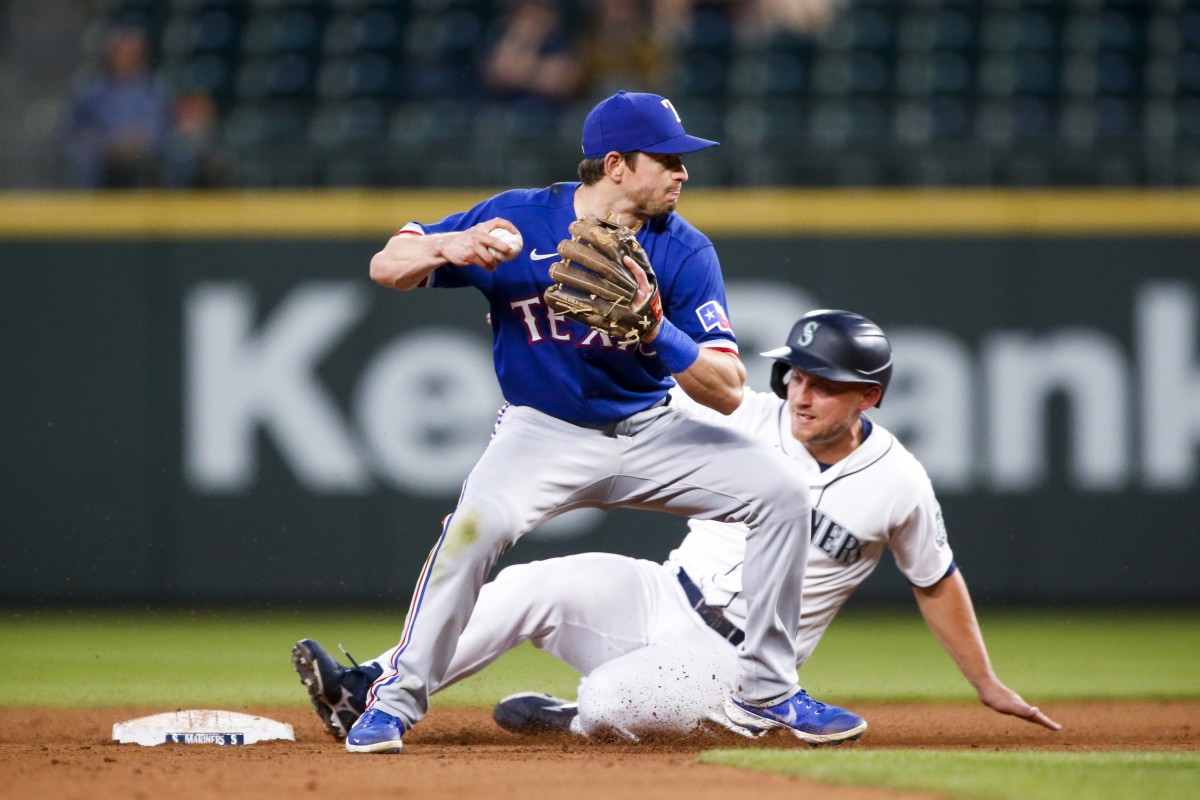 May 29, 2021; Seattle, Washington, USA; Texas Rangers second baseman Nick Solak (15) attempts to turn a double play against Seattle Mariners designated hitter Kyle Seager (15) during the sixth inning at T-Mobile Park.