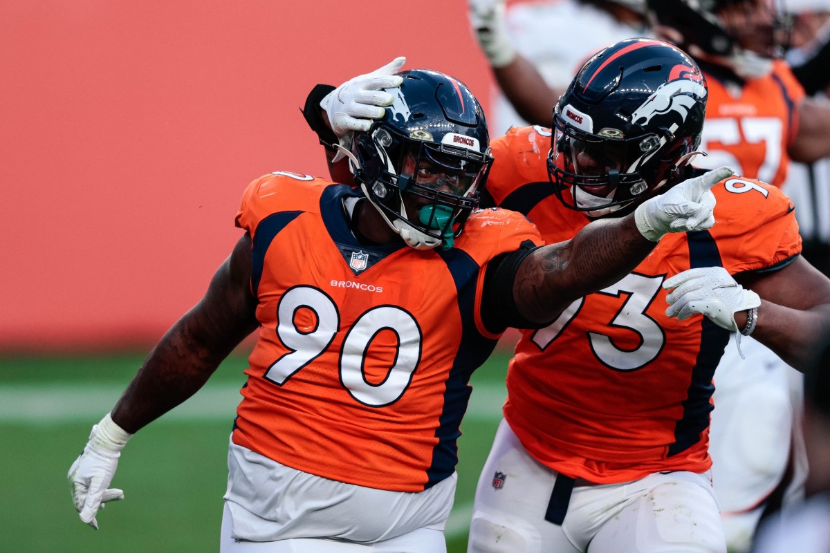 Denver Broncos defensive tackle DeShawn Williams (90) celebrates his sack with defensive end Dre'Mont Jones (93) in the third quarter against the Miami Dolphins at Empower Field at Mile High.