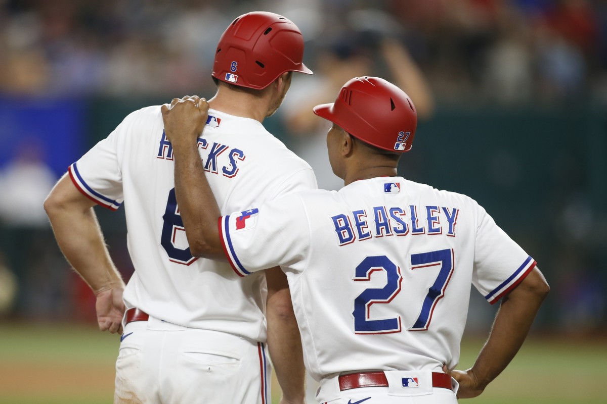 Jul 6, 2021; Arlington, Texas, USA; Texas Rangers third base coach Tony Beasley (27) talks with catcher John Hicks (6) after he reached third base in the seventh inning against the Detroit Tigers at Globe Life Field.